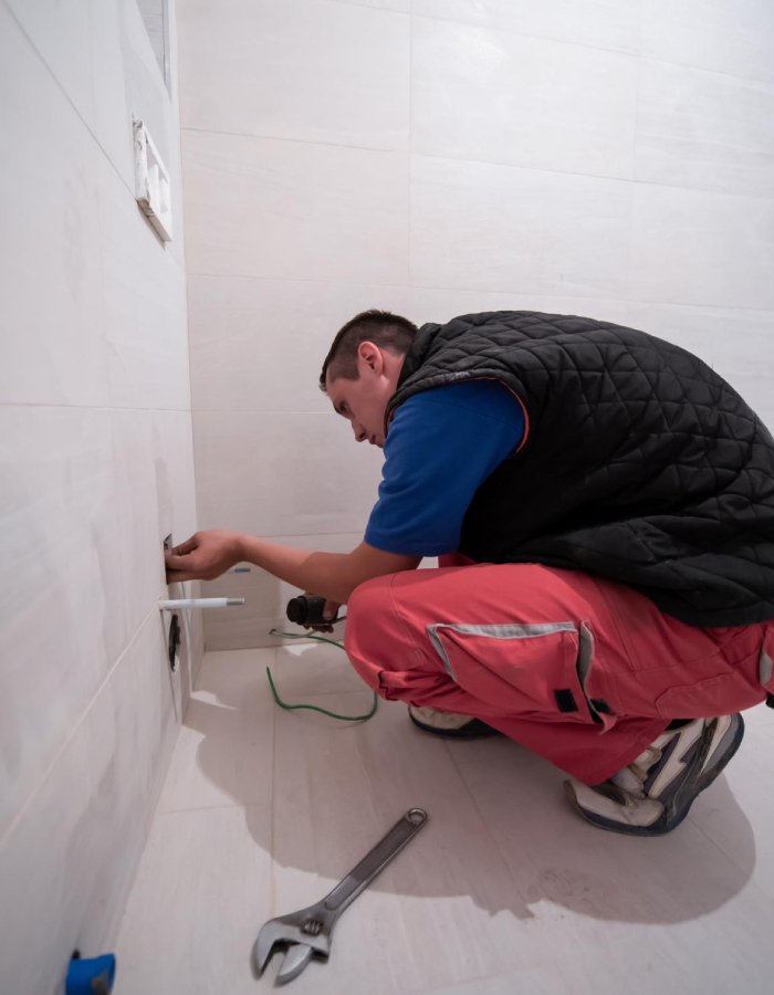 Plombier réalisant les raccordements sanitaires d’une salle de bain