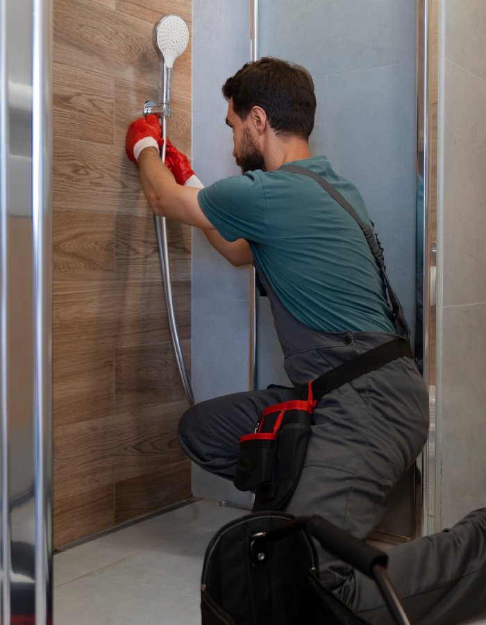 Plombier installant une douche lors d’une rénovation de salle de bain
